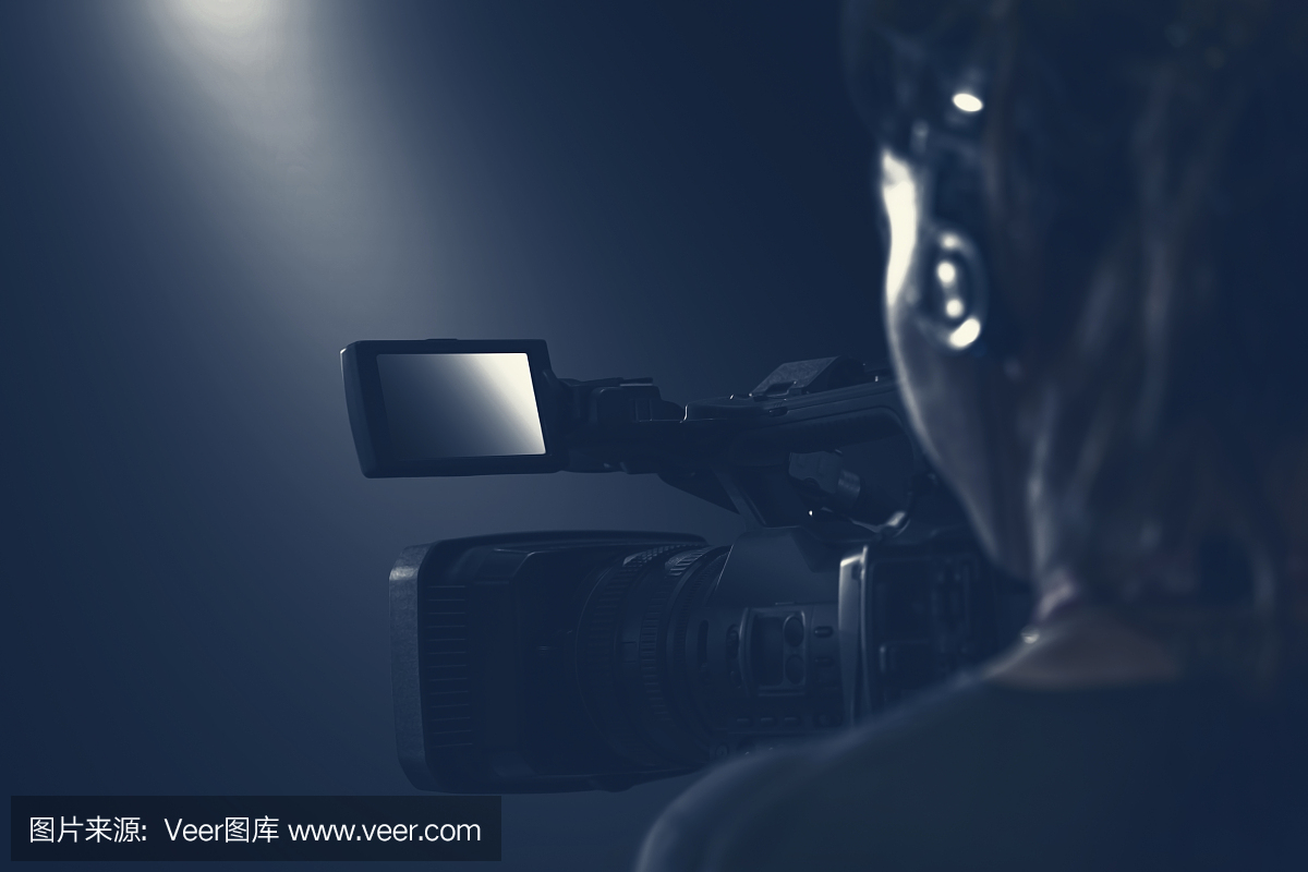 视频操作员用摄像机和音频耳机制作视频片段。